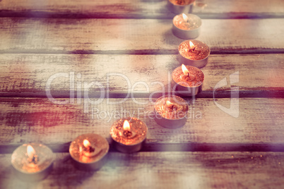 Candles burning on wooden plank