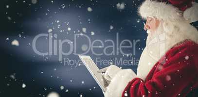 Composite image of santa uses a tablet pc