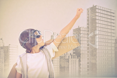 Composite image of boy wearing flying goggles with hand raised