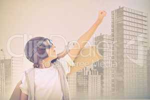 Composite image of boy wearing flying goggles with hand raised
