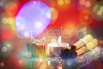 Cinnamon stick with lit candle and gift