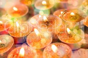 Close-up of candles burning on wooden plank
