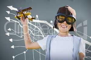 Composite image of portrait of boy wearing flying goggles with toy