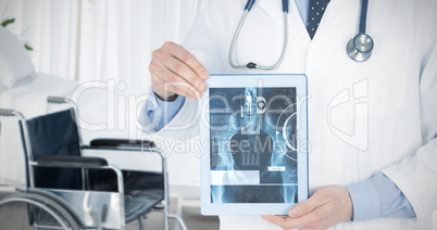 Composite image of doctor showing a digital tablet