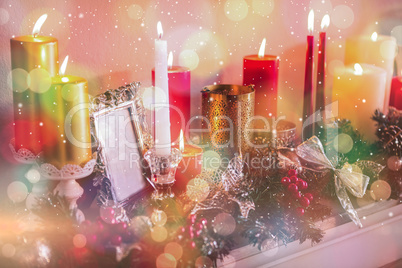 Candles and christmas decorations arranged on fireplace