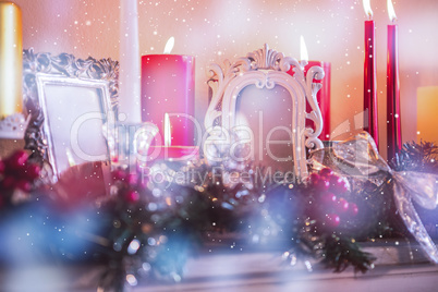 Candles and christmas decorations arranged on fireplace