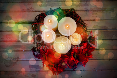 Candles decorated with flowers nest basket on wooden plank