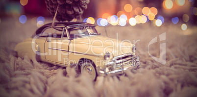 Toy car carrying christmas pine cone