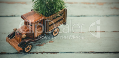 Toy tempo carrying christmas fir on wooden plank