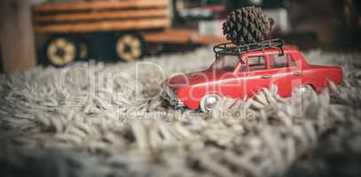 Toy car carrying christmas pine cone