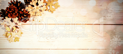 Snowflakes and pine cone on wooden plank
