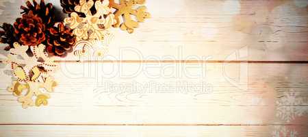 Snowflakes and pine cone on wooden plank