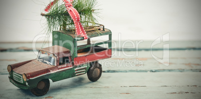 Toy tempo carrying christmas fir on wooden plank