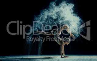 Graceful woman dancing in cloud of dust