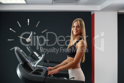 Sport time. Beautiful girl exercising on treadmill