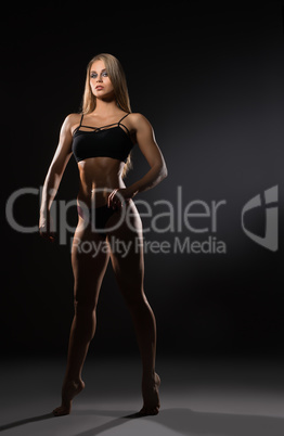 Attractive female bodybuilder posing at camera