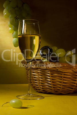 White wine in a glass and grapes