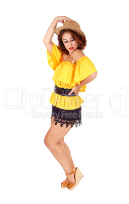 Woman posing in shorts and hat.