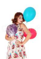 Woman with balloons and lollipop.