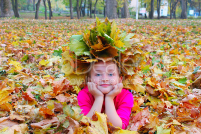 girl with a wreath of yellow leaves smiles