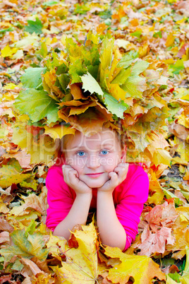 girl with a wreath of yellow leaves smiles