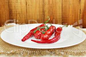 pods of chili peppers and cherry tomatoes on the plate