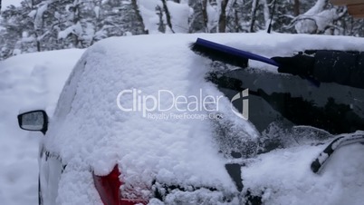 Driver Removes a Snow from the Rear Window