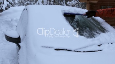 Driver Removes a Snow from the Windshield