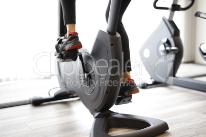 Woman at the fitness gym biking