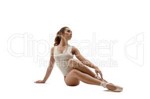 Beautiful ballet dancer sitting. Isolated on white