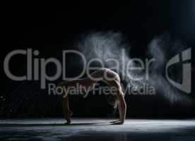 Dancer performs acrobatic trick in cloud of dust