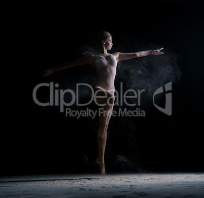 Dancer jumping gracefully in cloud of powder