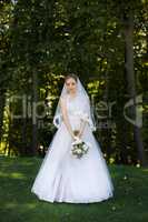 Beautiful bridal bouquet in hands of young bride dressed in white wedding dress.