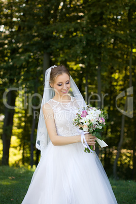 Beautiful bridal bouquet in hands of young bride dressed in white wedding dress.