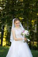 Beautiful bridal bouquet in hands of young bride dressed in white wedding dress.