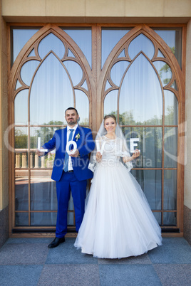 Newlyweds are holding the letter in his hands on a photo shoot
