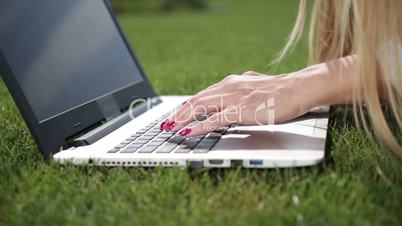 Businesswoman hands typing on a laptop outdoor