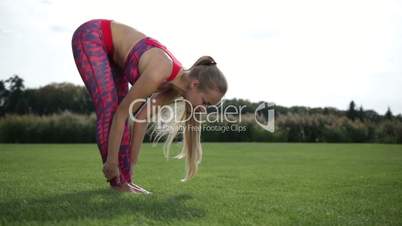 Fit young woman doing standing forward bend