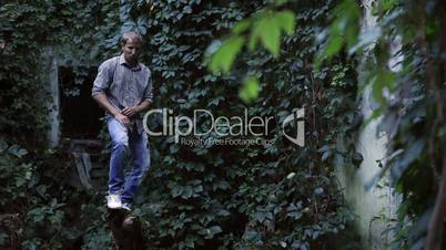 Young handsome man balancing on a dead tree