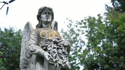 Ancient statue of guardian angel at old cemetery
