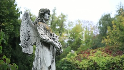 Sculpture of stone angel praying at the cemetery