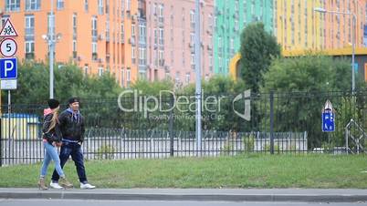 Trendy young couple walking together hand by hand