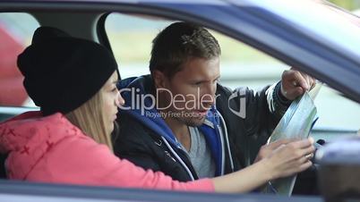 Cute couple in car looking for the right direction