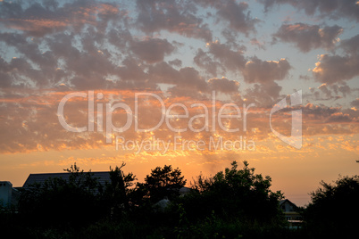 View of a Beautiful Sunset Sky above the houses and trees.