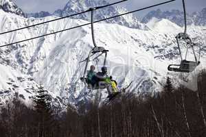 Father and daughter on ski-lift at nice sunny day