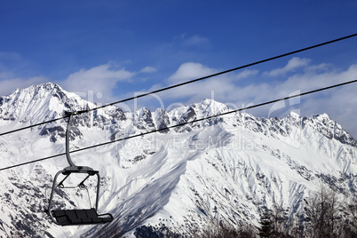 Chair-lift in snow winter mountains at nice sunny day