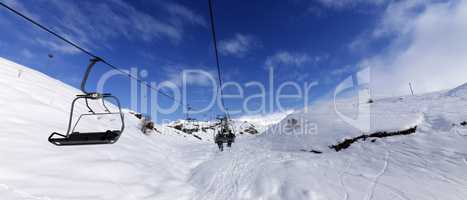 Panoramic view on chair-lift at ski resort at sun winter day