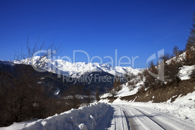 Ice-covered road in winter snow mountain at sun cold morning