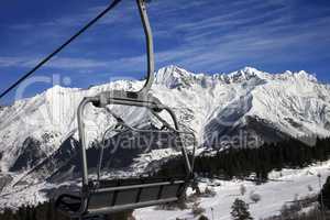 Chair-lift at ski resort and snow winter mountains in nice sun d