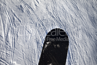 Snowboard over off-piste slope with track from ski and snowboard